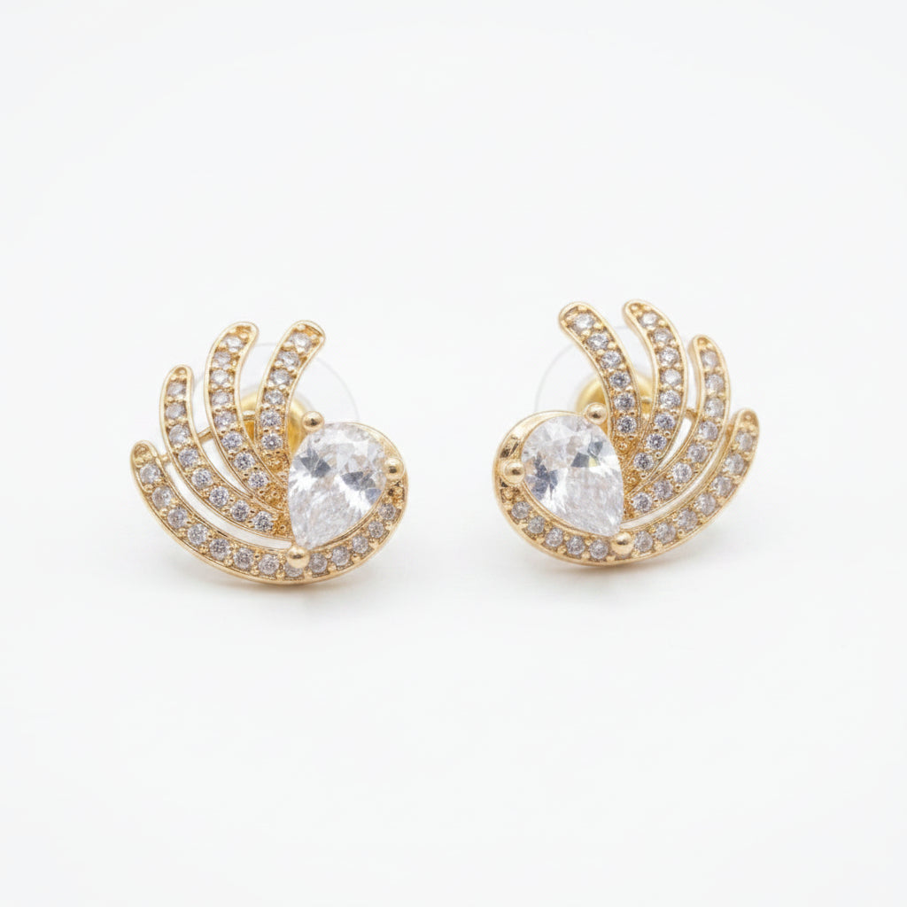 A pair of gold crescent-shaped stud earrings with a central clear teardrop gemstone and surrounding pavé-set clear stones, shown on a plain white background.