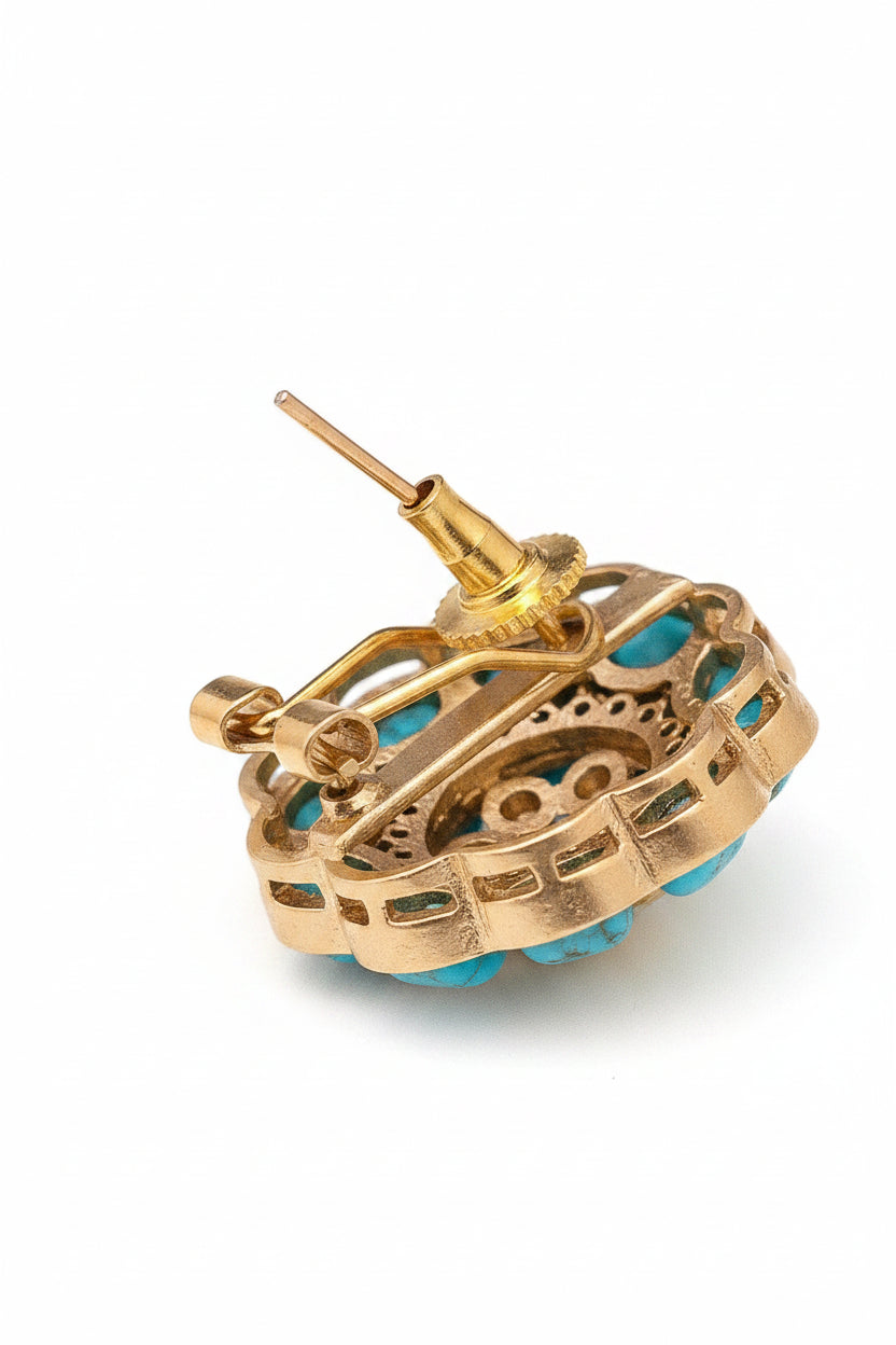 Gold earring with turquoise stones on a black background