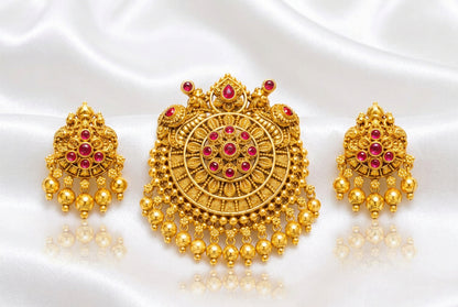 Intricate traditional round pendant with green and red stones (ruby and emerald colored), paired with matching jhumka-style drop earrings.